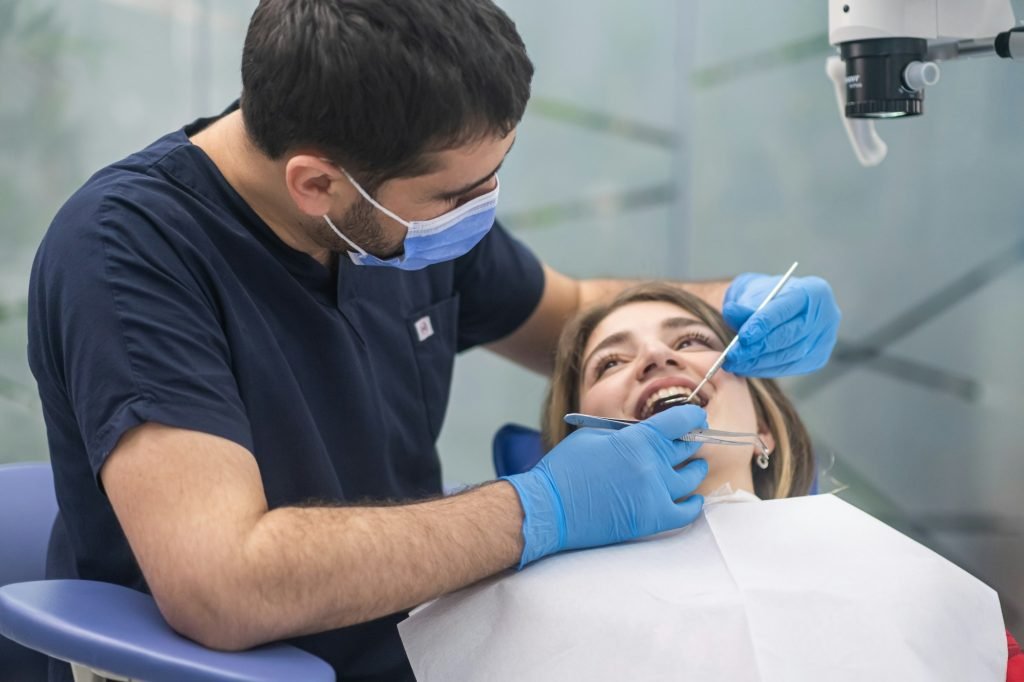 Dental care in modern clinic focused orthodontist looking at teeth of female patient