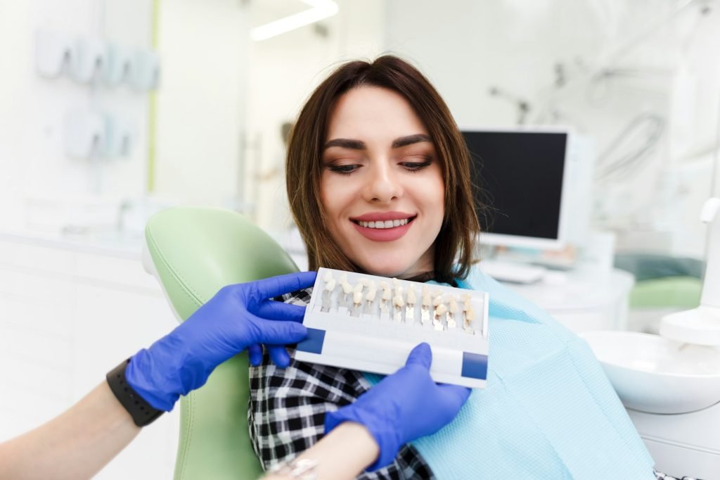 Dentist and his patient choose a tone of veneers.